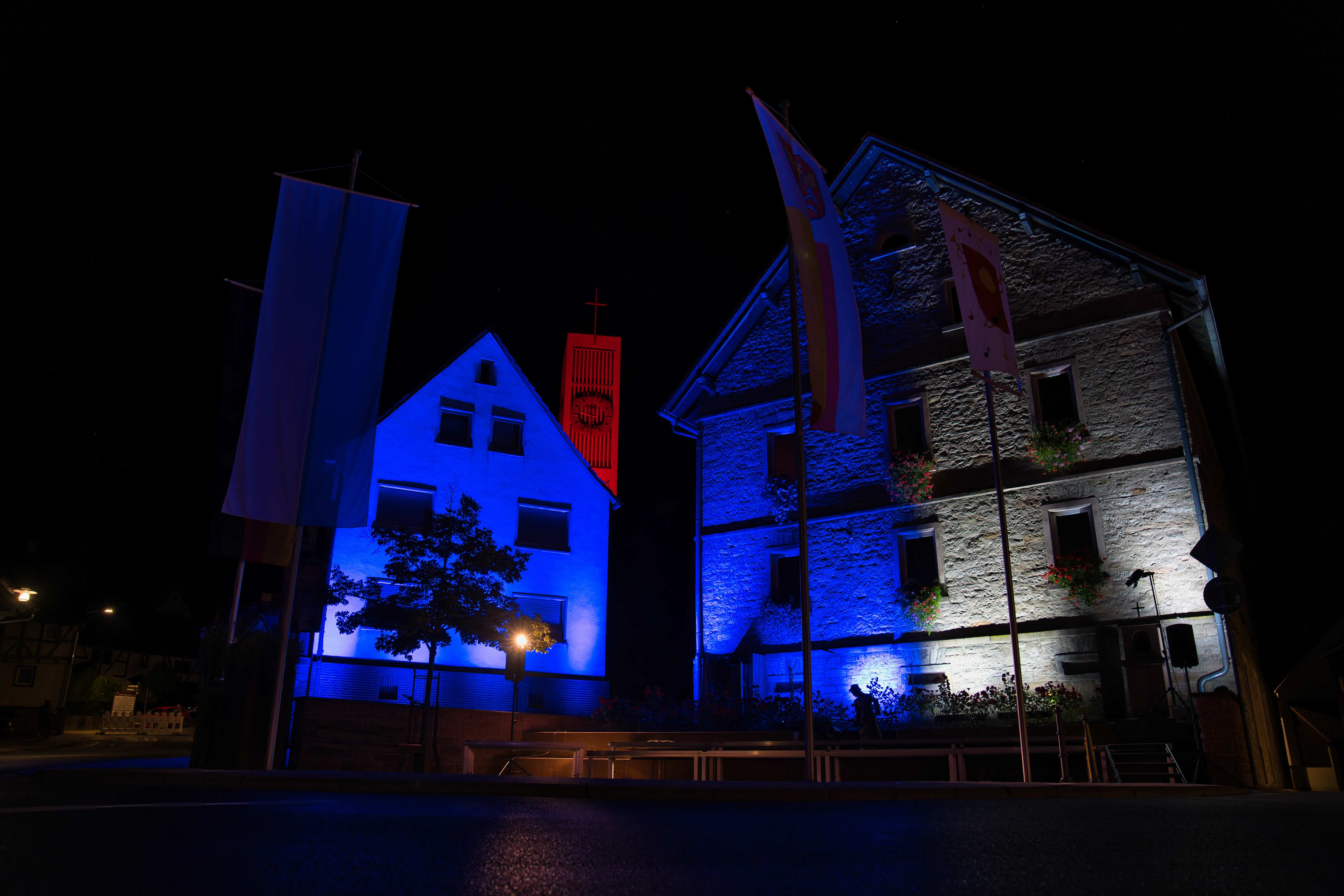 Blau und rot beleuchtete Fachwerkhäuser bei einer Veranstaltung in Laufach