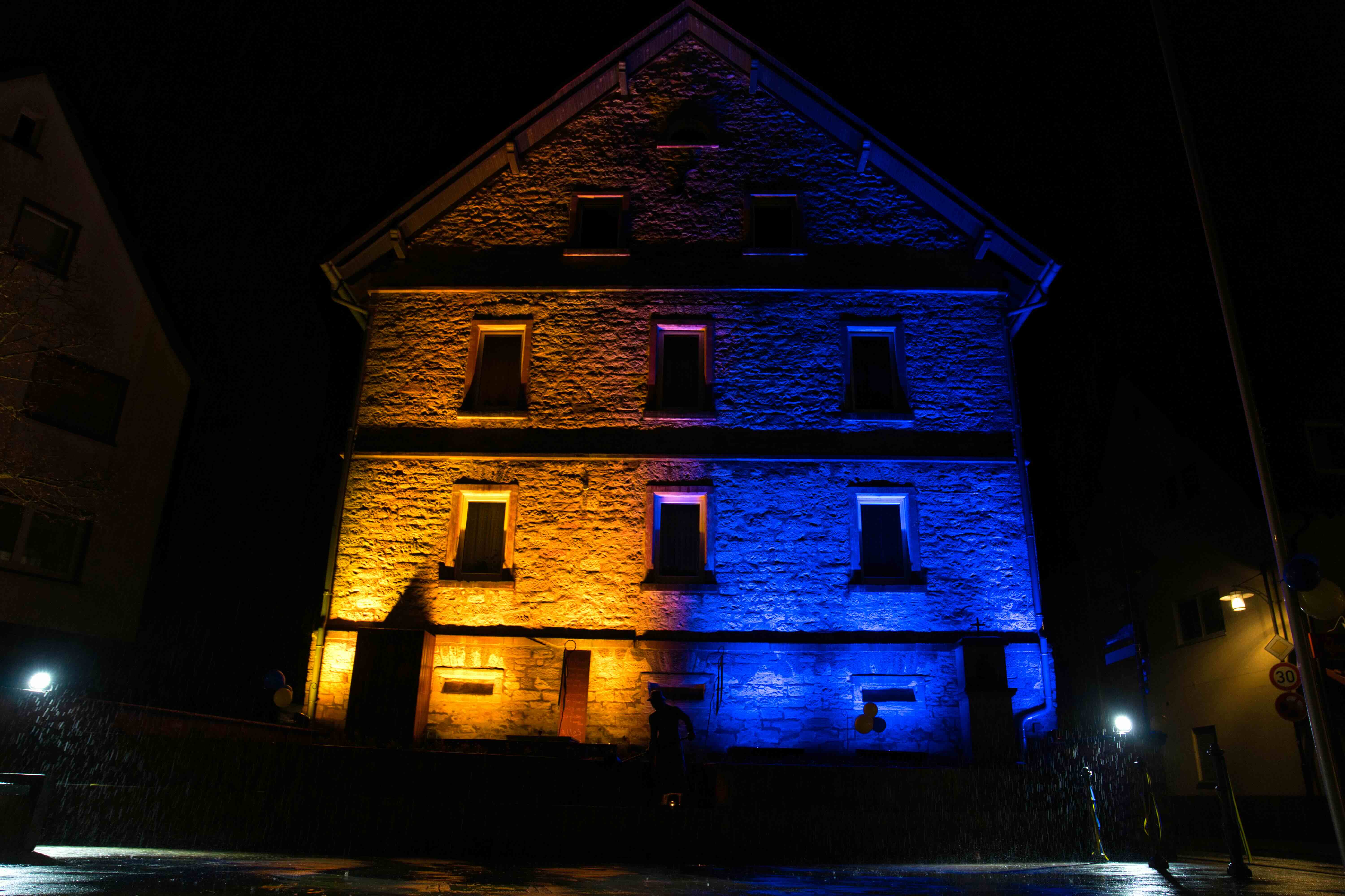 Haus im Ortszentrum in Blau und Gelb beleuchtet